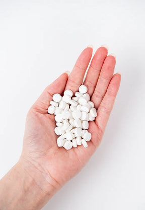 vegane Zahnputz Tabletten in der Hand,  1 Packung ersetzt 2 Zahnpastatuben, frei von Mikroplastik